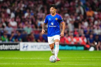 Lisandro Martinez of Manchester United, wearing the blue away kit with Snapdragon sponsor and white shorts, controls the UEFA Champions League ball on the pitch during the UEFA Champions League 2026/27 League Phase MD2 match between Atletico de Madrid and Manchester United at Estadio Metropolitano on October 13, 2026, in Madrid, Spain.