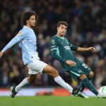 Football action with Brighton player in green kit controlling ball while Manchester City player in light blue kit challenges from behind on green pitch  trybalnews