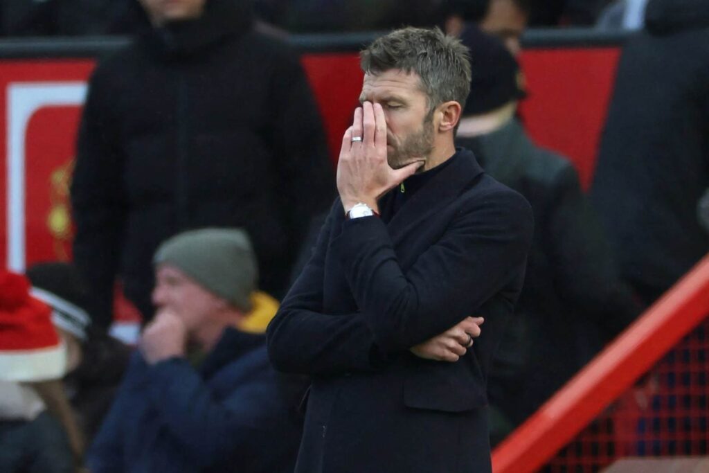 Micheal Carrick Trybal News Michael Carrick Manchester United head coach in black coat with hand over face looking frustrated on the touchline during Premier League match against Bournemouth at Old Trafford trybalnews