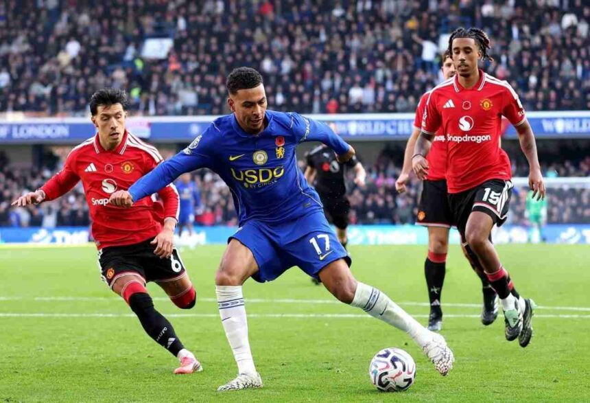 Chelseas Morgan Rogers wearing the blue No 17 kit runs with the ball past Manchester United defenders in red during the Premier League match at Stamford Bridge  trybalnews