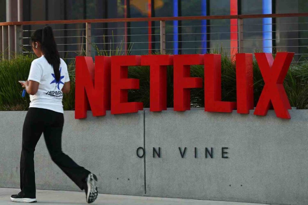 Netflix Trybal News The Netflix logo in large red 3D letters on a concrete wall that reads ON VINE outside the Netflix Tudum Theater in Los Angeles California on May 29 2026 as a woman walks past looking at her phone trybalnews