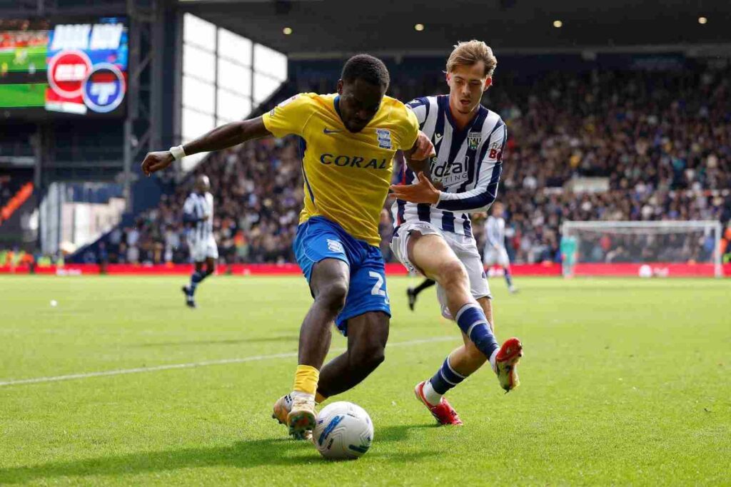 OsayiSamuel Trybal News Birmingham Cityaposs Bright Osayi Samuel in yellow and blue dribbles the ball while being challenged by West Bromwich Albionaposs Isaac Price in a striped shirt during a Championship match at The Hawthorns trybalnews
