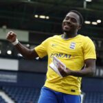 Birmingham City player Bright Osayi Samuel smiles and raises a fist while holding a Sky Bet Player of the Match trophy He is wearing Birminghams yellow away shirt at The Hawthorns stadium  trybalnews