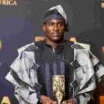 Nigerian footballer Taiwo Awoniyi wearing traditional black and silver agbada and fila cap holding gold BoA trophy at Best of Africa Awards ceremony  trybalnews