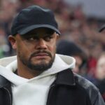 Vincent Kompany wearing black cap white hoodie and black jacket looking to side before Bayern Munich vs Arsenal Champions League match in Munich  trybalnews